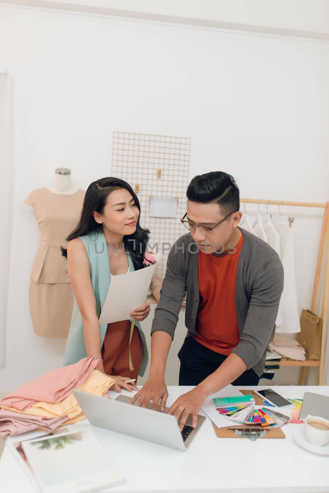 Young woman and man fashion designer using laptop to search for new ideas