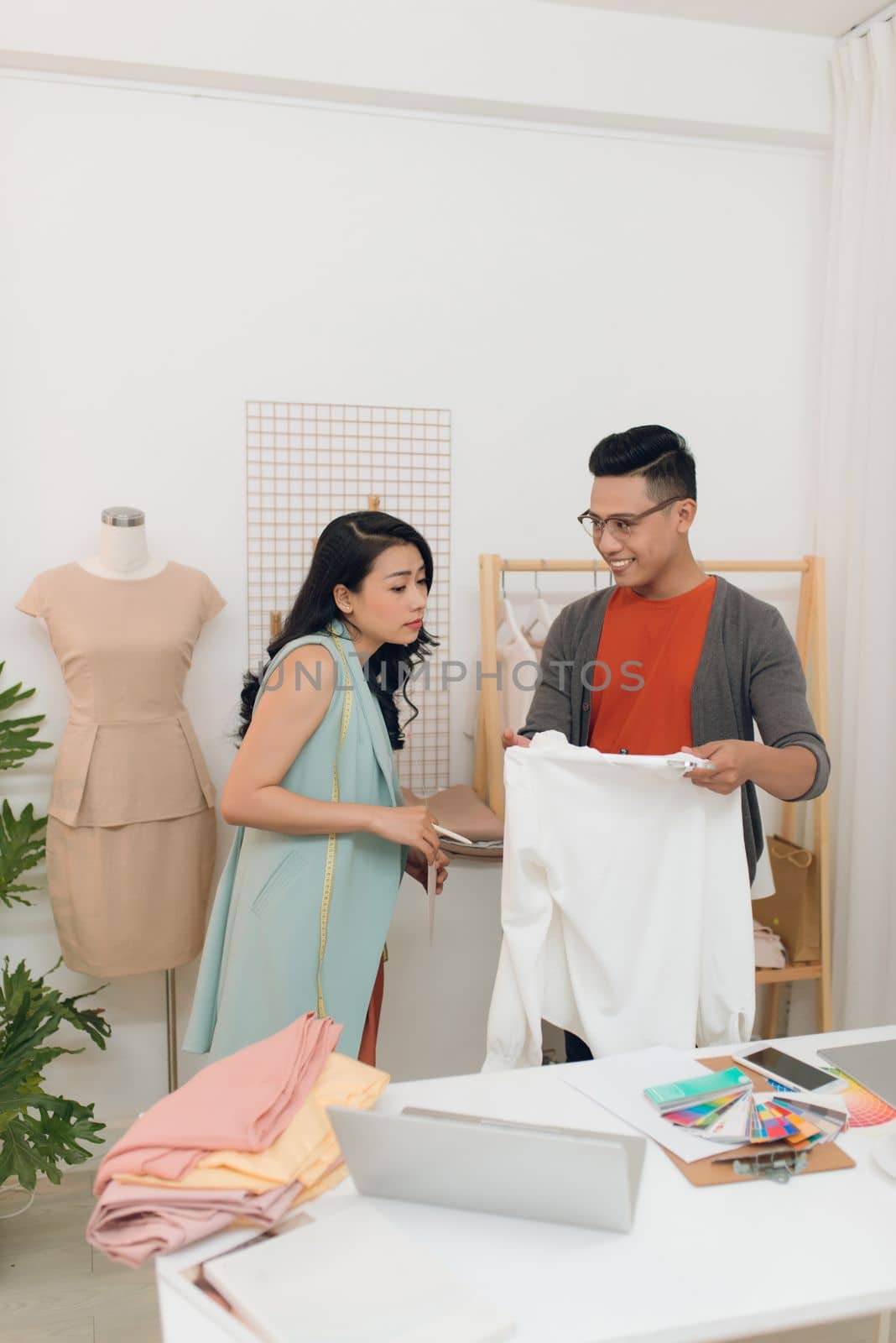 Two fashion designers working together on a desk by makidotvn