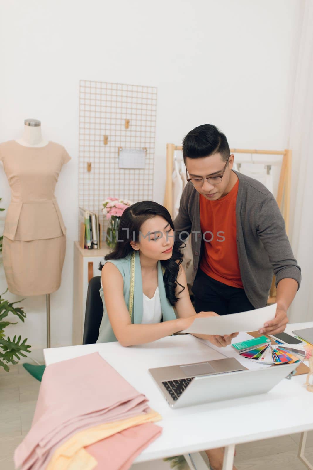 Two fashion designers working together on a desk by makidotvn
