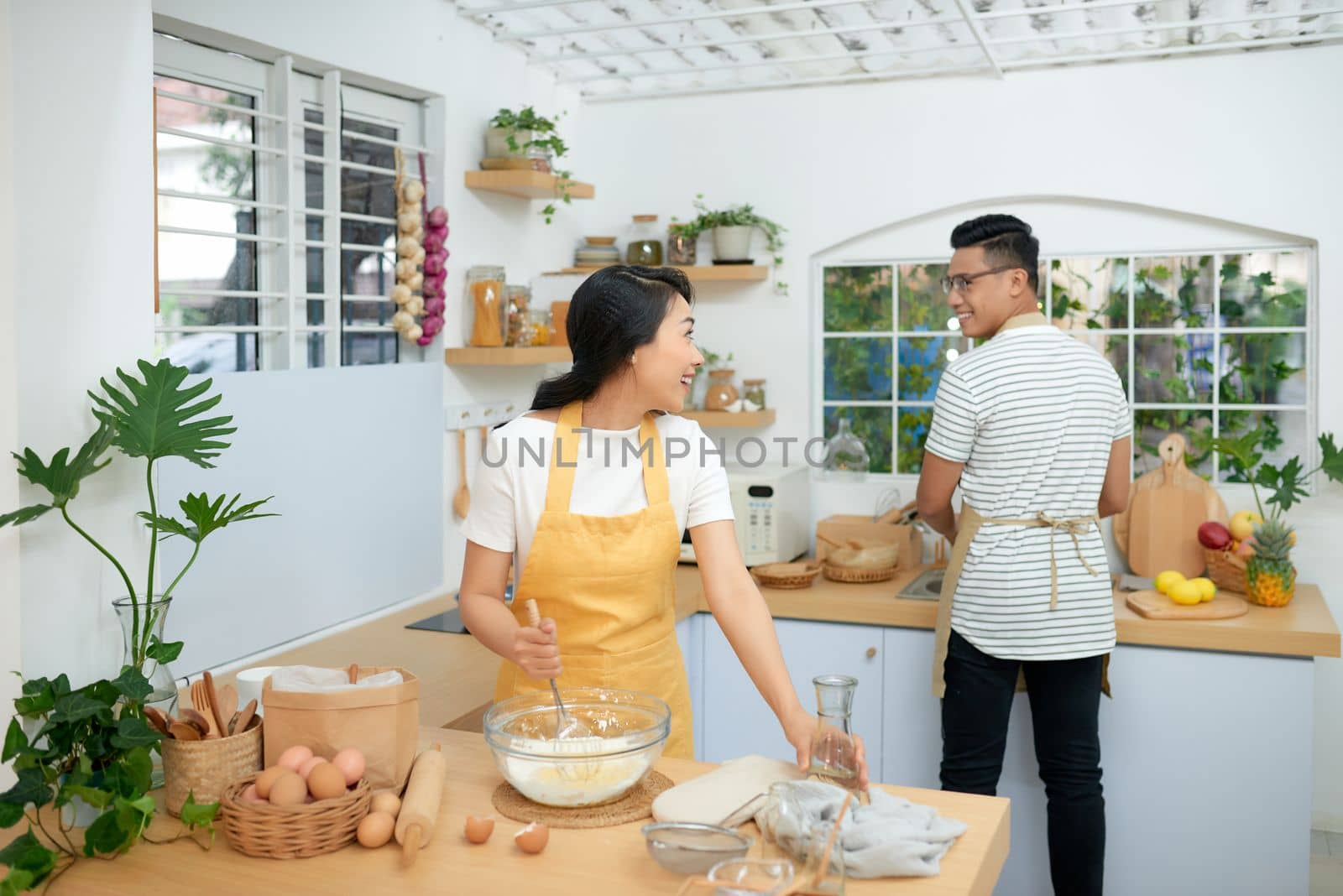 Couple cooking bakery in kitchen room, Young asian man and woman together making cake and bread with egg, by makidotvn
