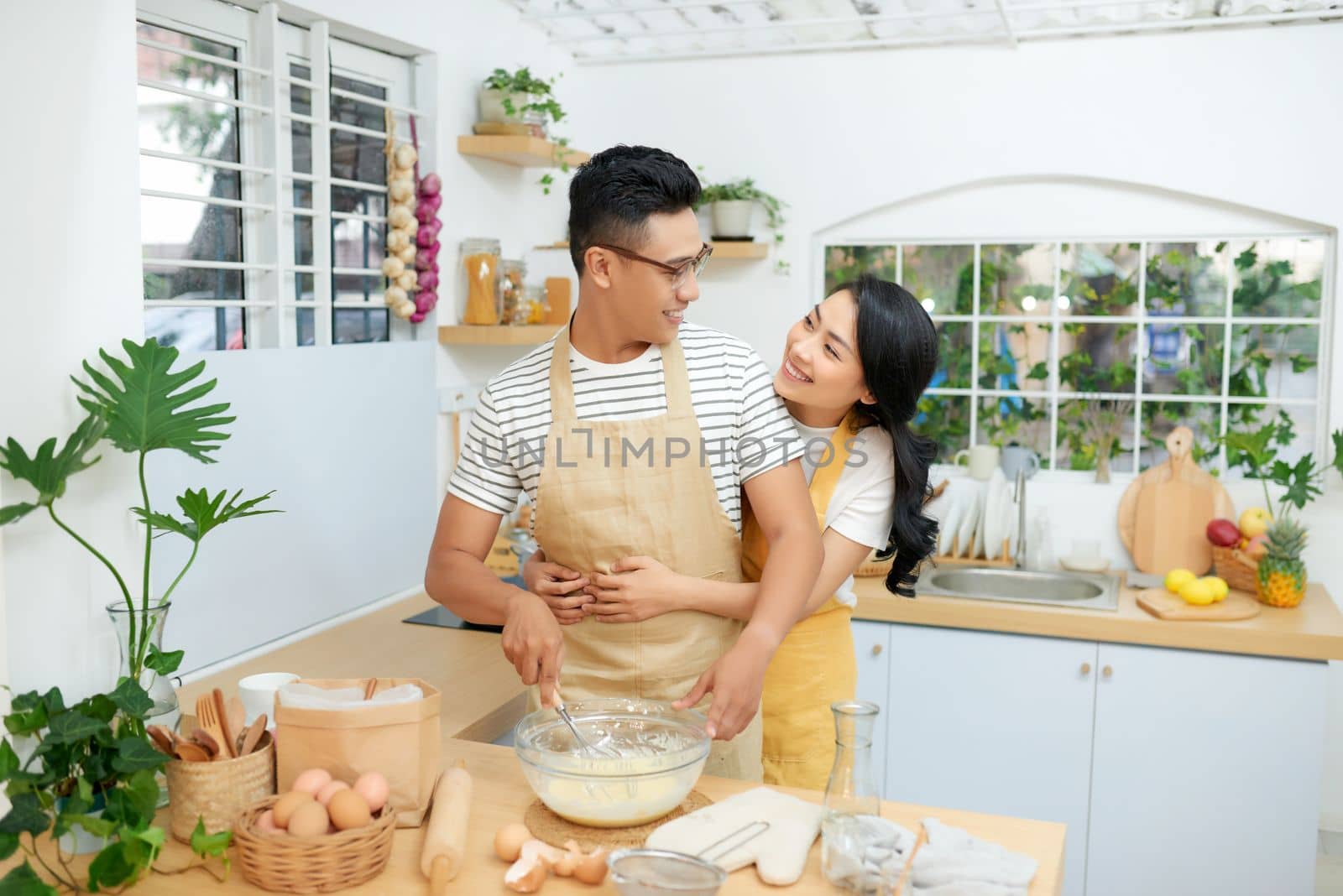 Couple cooking bakery in kitchen room, Young asian man and woman together making cake and bread with egg, by makidotvn