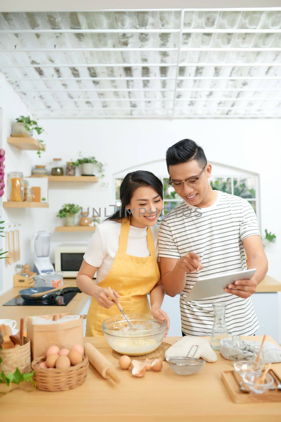 Young family cooking at home, using digital tablet. Mockup for recipe