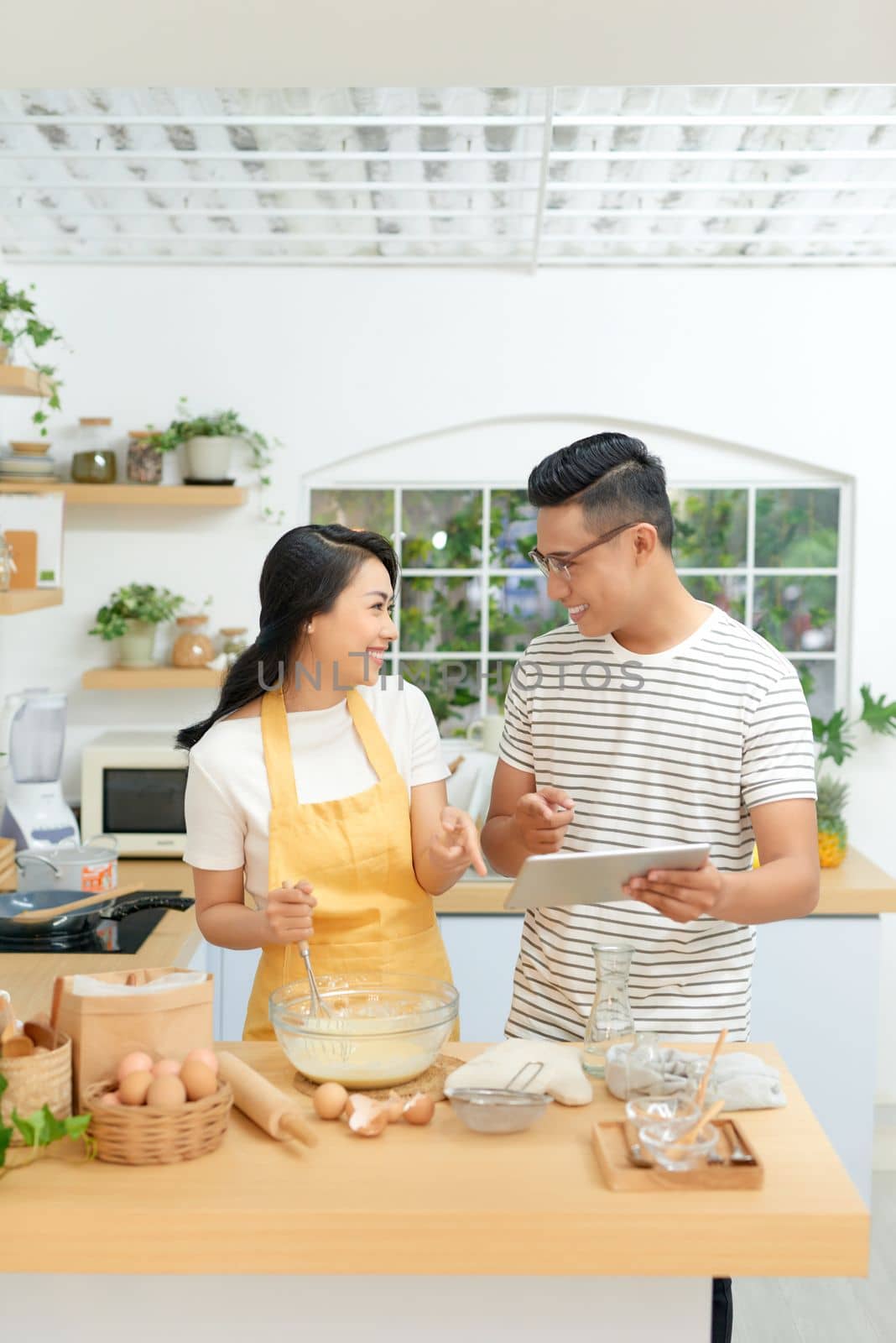 Couple in kitchen looking at recipe on internet by makidotvn