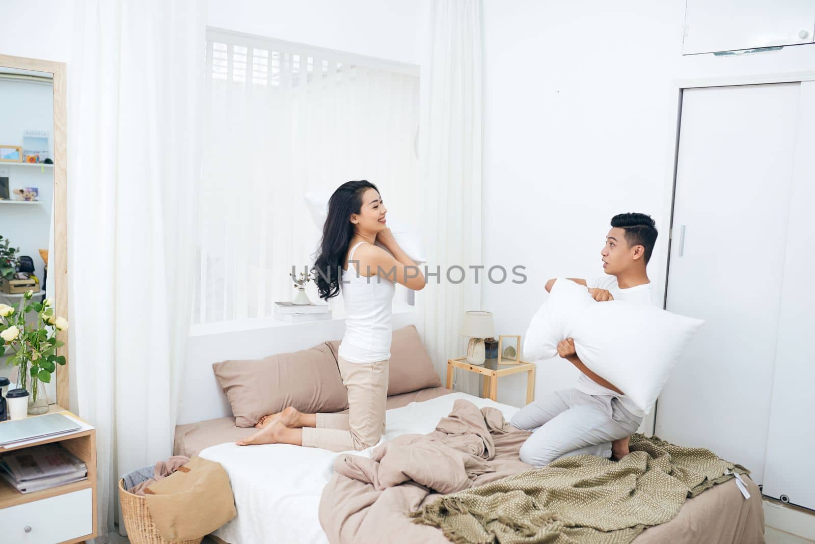 Picture showing happy couple having pillow fight