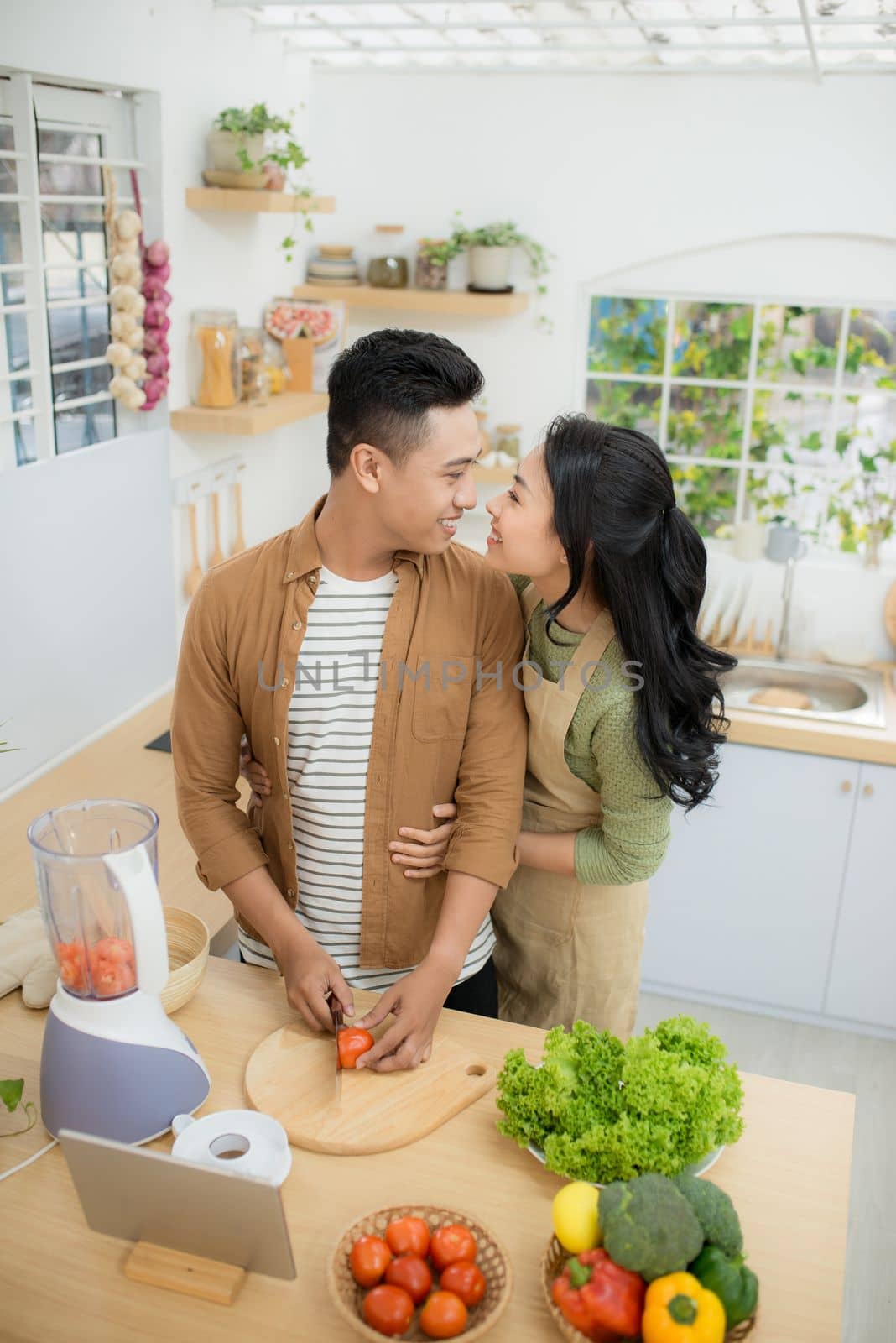 Young Asian couple. Standing cooking in the kitchen. 