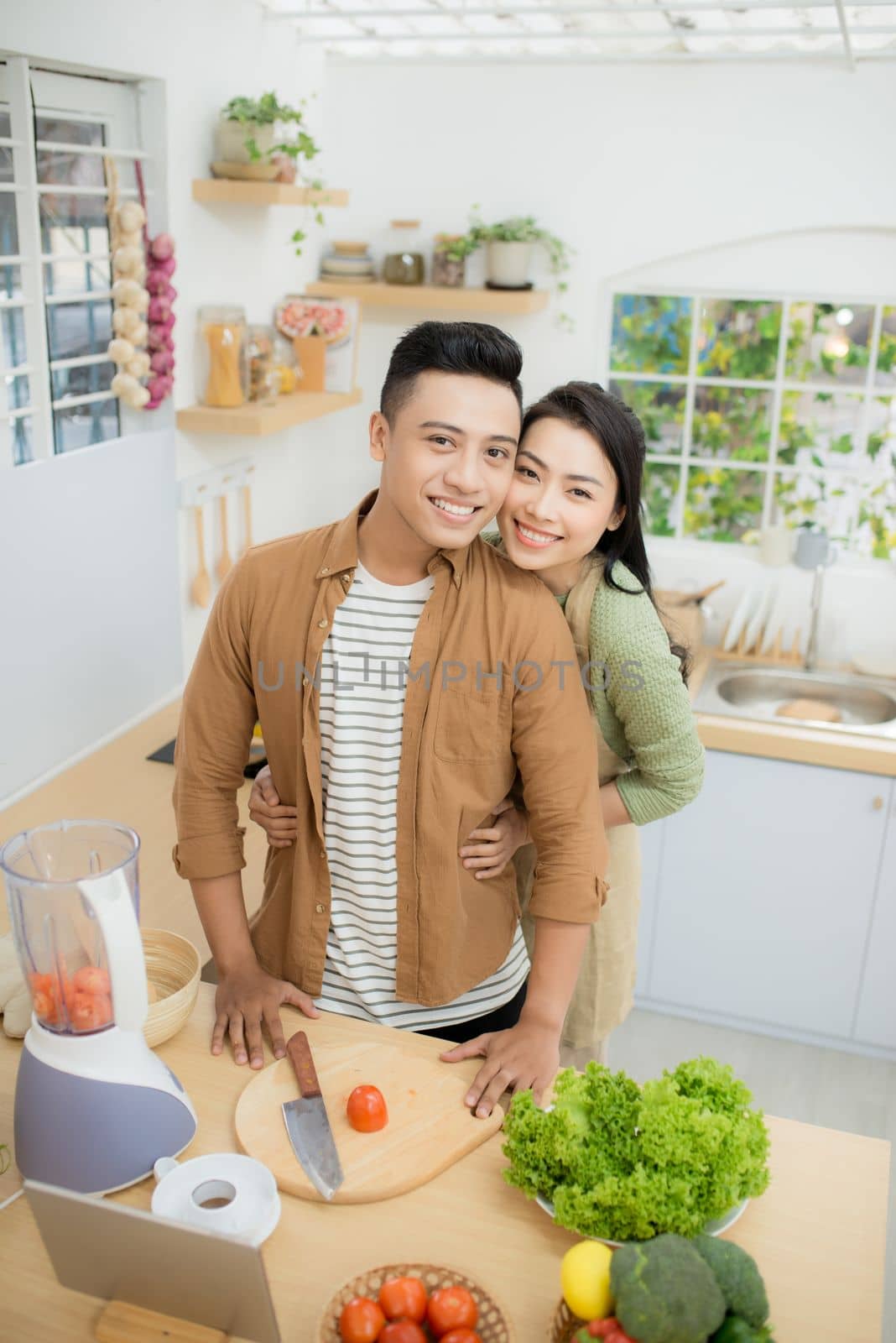 Young Asian couple. Standing cooking in the kitchen. 