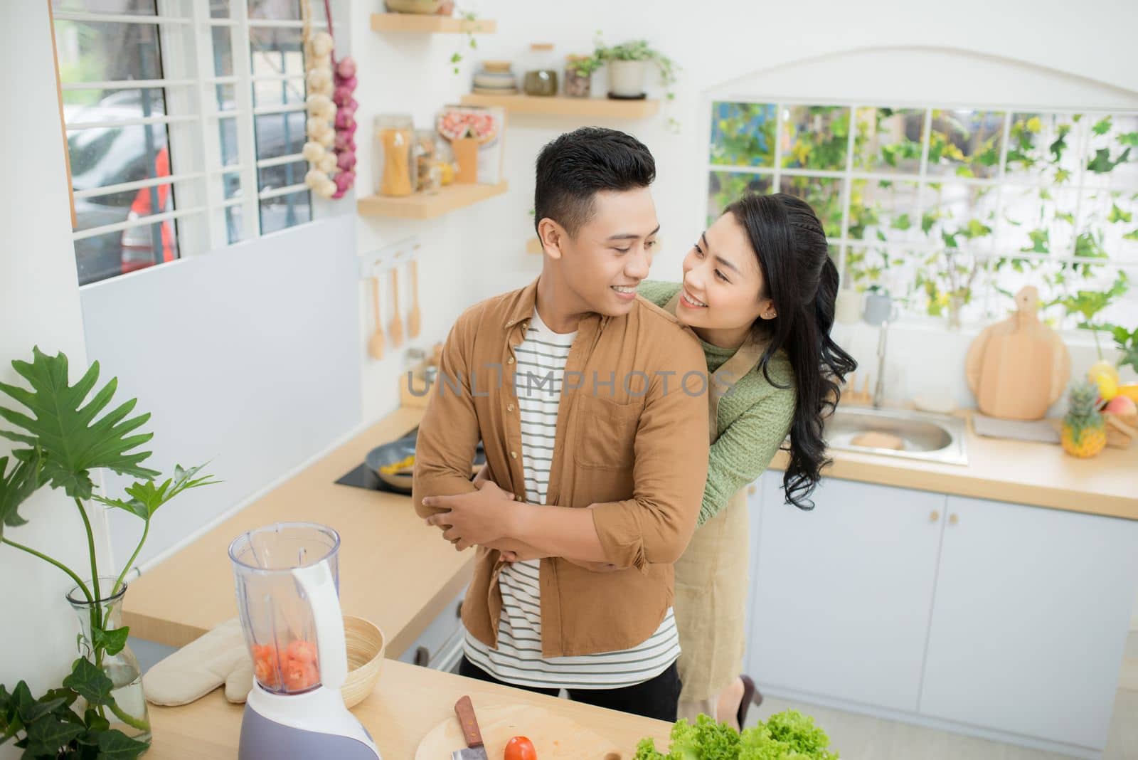 young asian couple cooking in kitchen