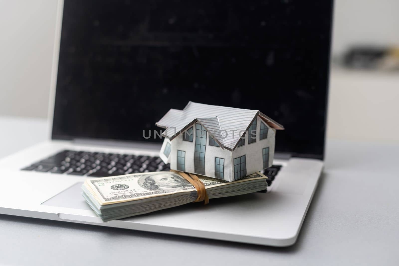 house model with dollar banknotes on laptop keyboard by Andelov13