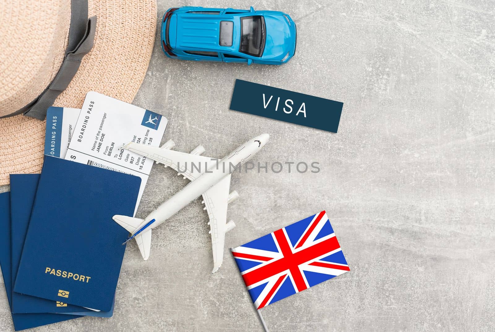 Flag of United Kingdom with passport and toy airplane on wooden background. Flight travel concept by Andelov13