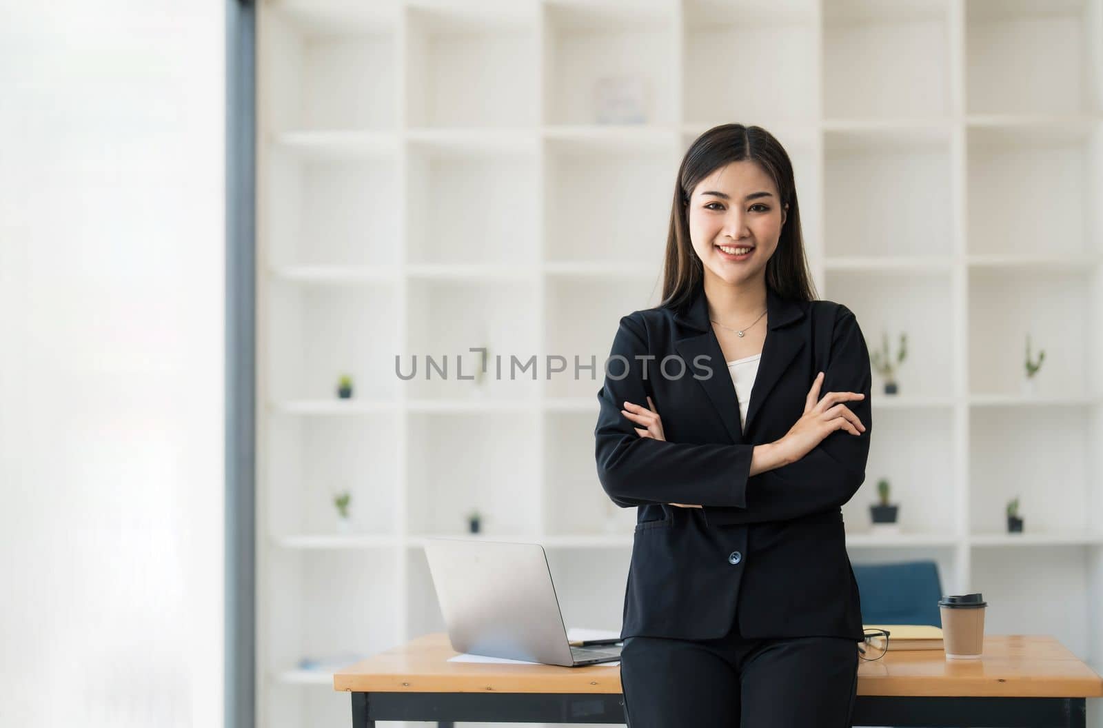 Beautiful Asian businesswoman crossed arms at the office looking at the camera. by wichayada