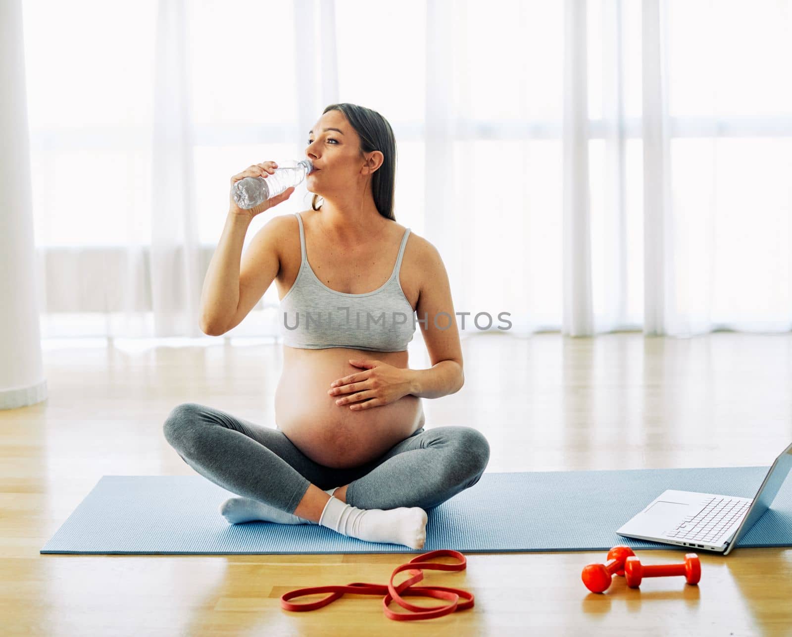 woman pregnant mother pregnancy female exercise sport fitness belly healthy maternity motherhood health yoga young dumbbell weight laptop computer online water drink bottle hydrate by Picsfive