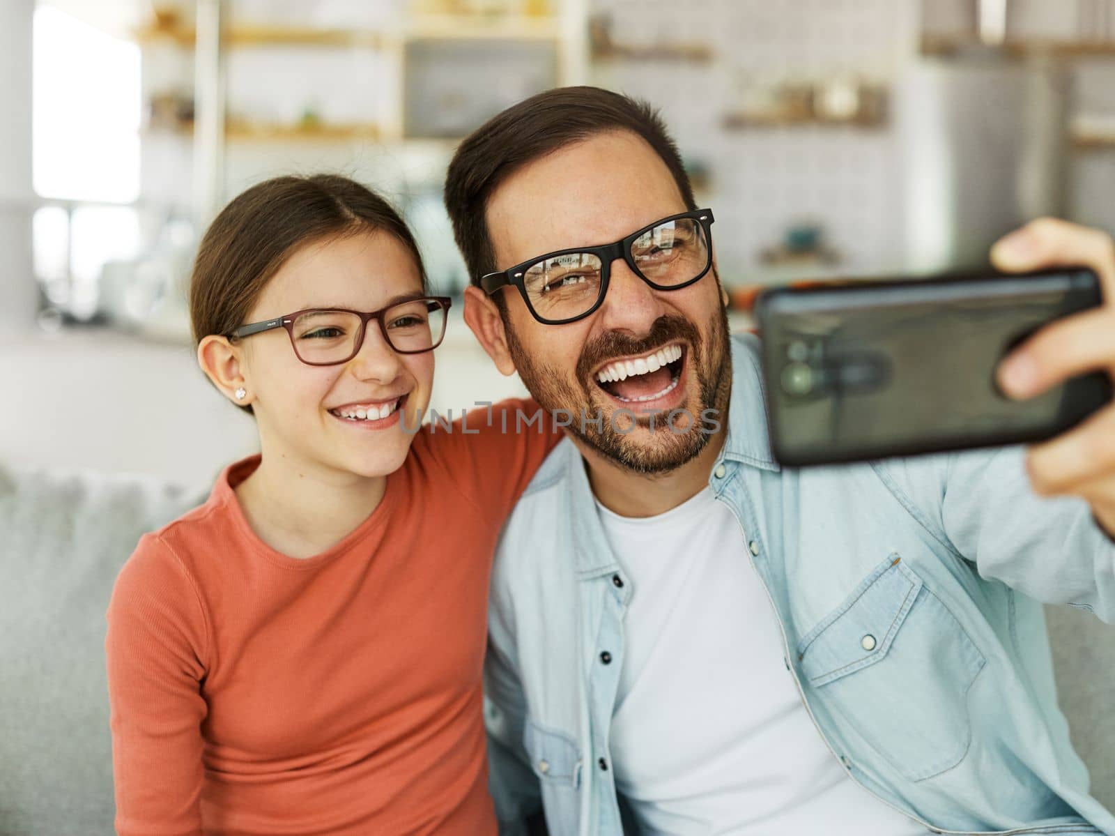 Family father and daughter having fun playing and making a selfie at home