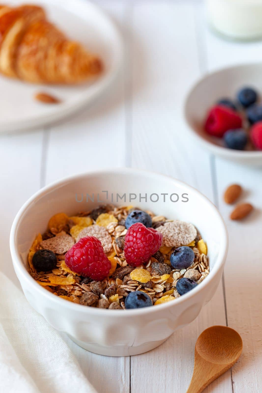 Breakfast bowl of oat flakes with berries, yoghurt and croissant by lanych