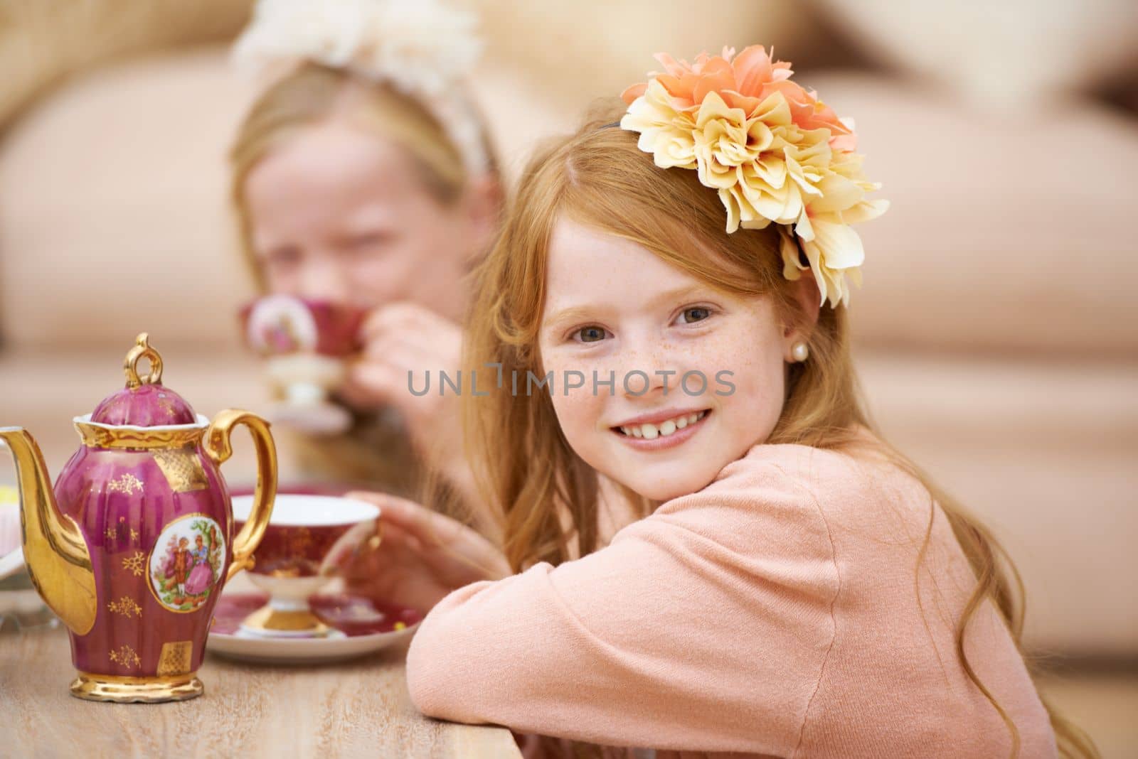 Enjoying a tea party with her friend. A cute young redhead enjoying a tea party with her friend. by YuriArcurs