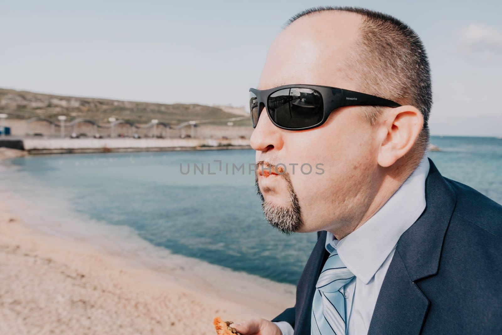 Male persimmon park. Hipster millennial man in a tie and jacket bites off a persimmon while sitting on a park bench in slow motion Young business people eat golden persimmons at lunchtime