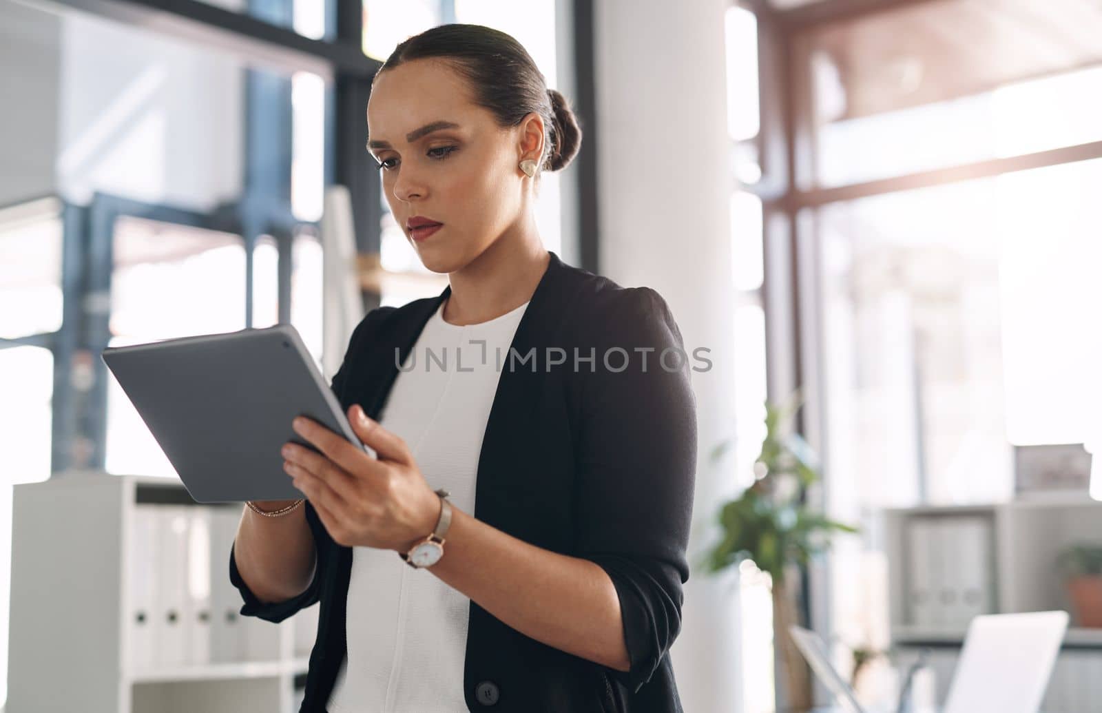 Technology helps grow your business even further. an attractive young businesswoman using a digital tablet inside her office. by YuriArcurs