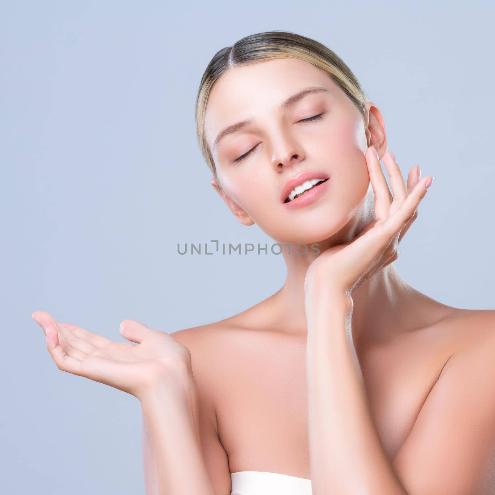 Alluring beautiful woman with perfect smooth and clean skin portrait in isolated background. Beauty hand gesture with expressive facial expression for skincare treatment product or spa.