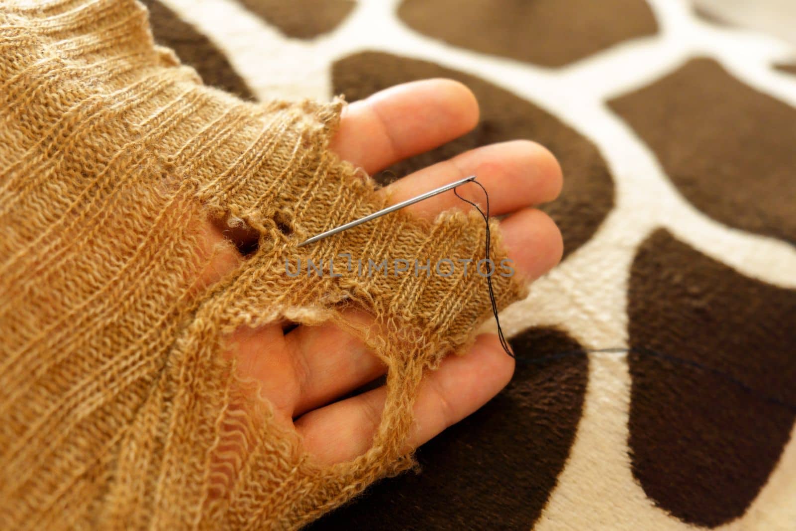 Mending clothes. Repairing woolen sweaters, shopping less concept. Selective focus