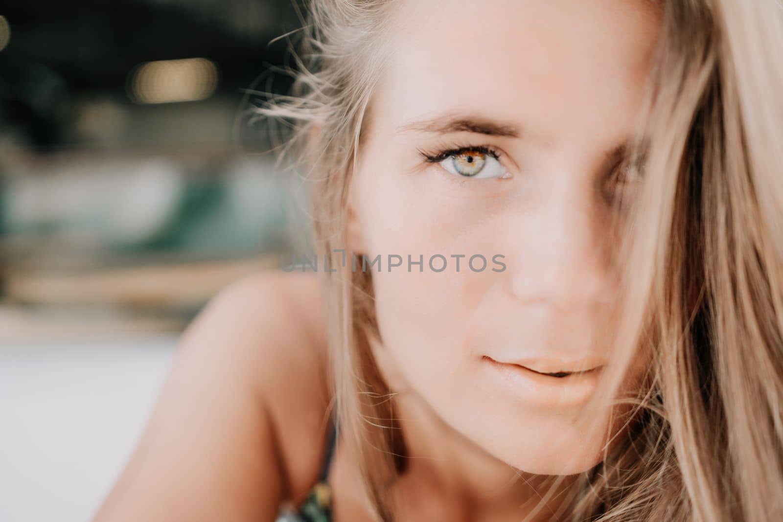 Happy woman portrait in cafe. Boho chic fashion style. Outdoor photo of young happy woman with long hair, sunny weather outdoors sitting in modern cafe