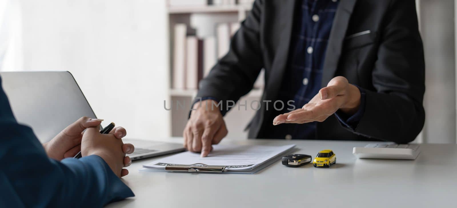 Car agent, sale man explain terms and agreement to customer before giving the car key to customer...