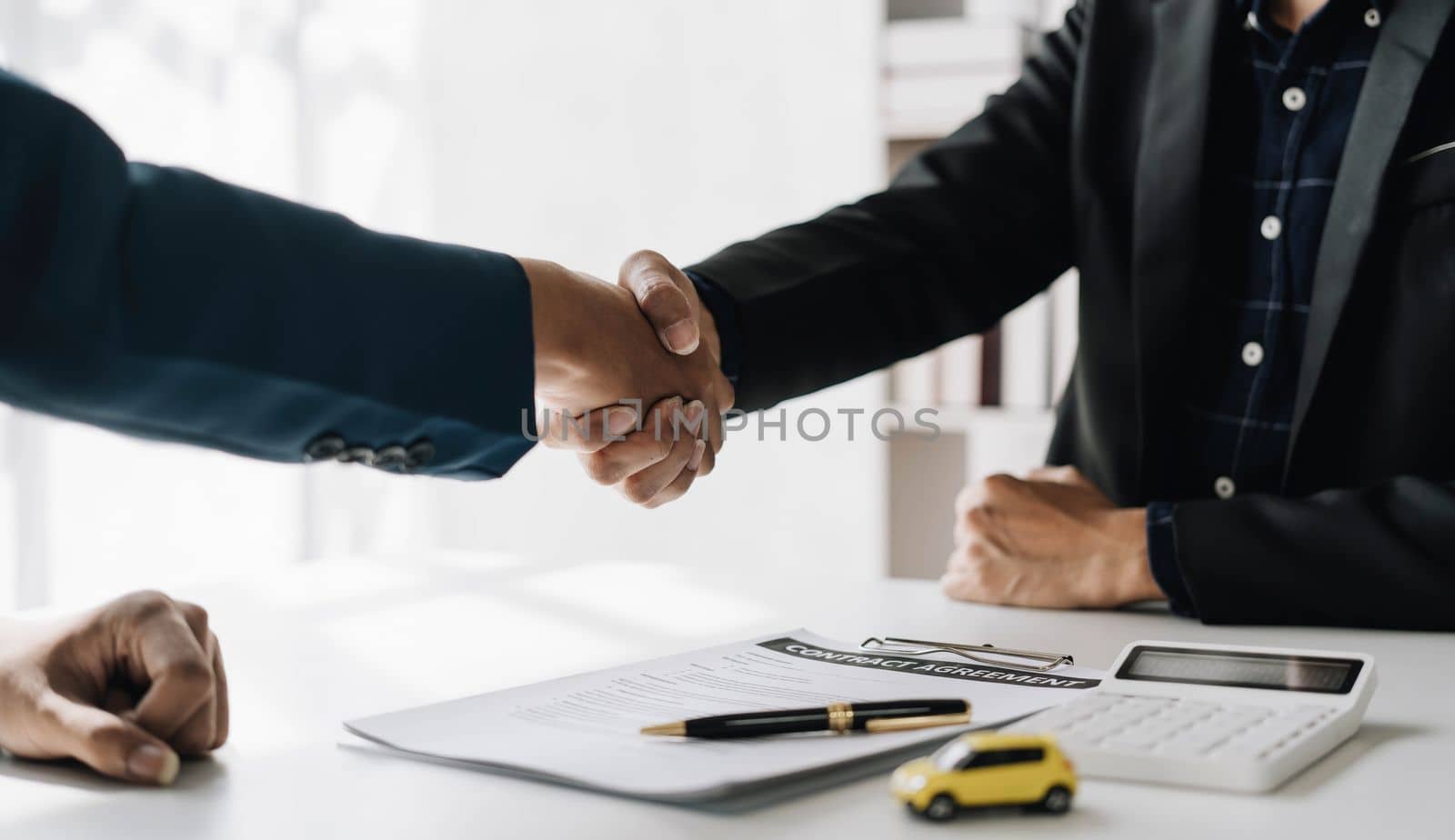 Handshake of cooperation customer and salesman after agreement, successful car loan contract buying or selling new vehicle by wichayada