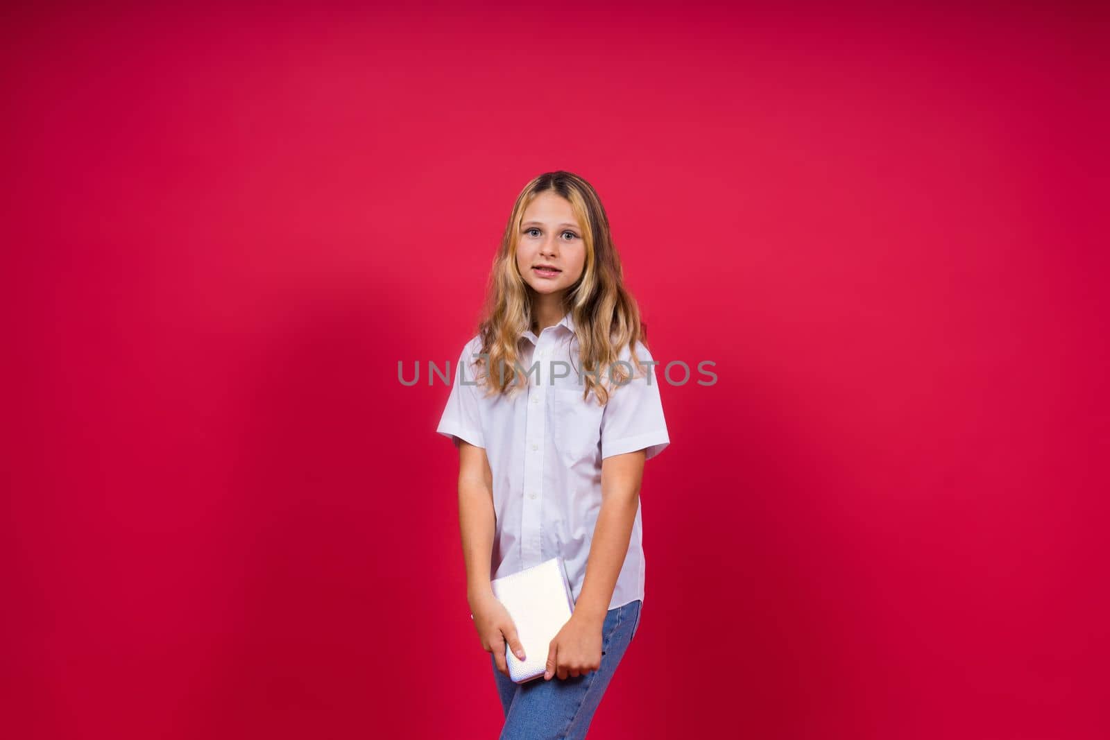 Child making notes. Kids dreams.Isolated on a red background. Education, Kid back to school.
