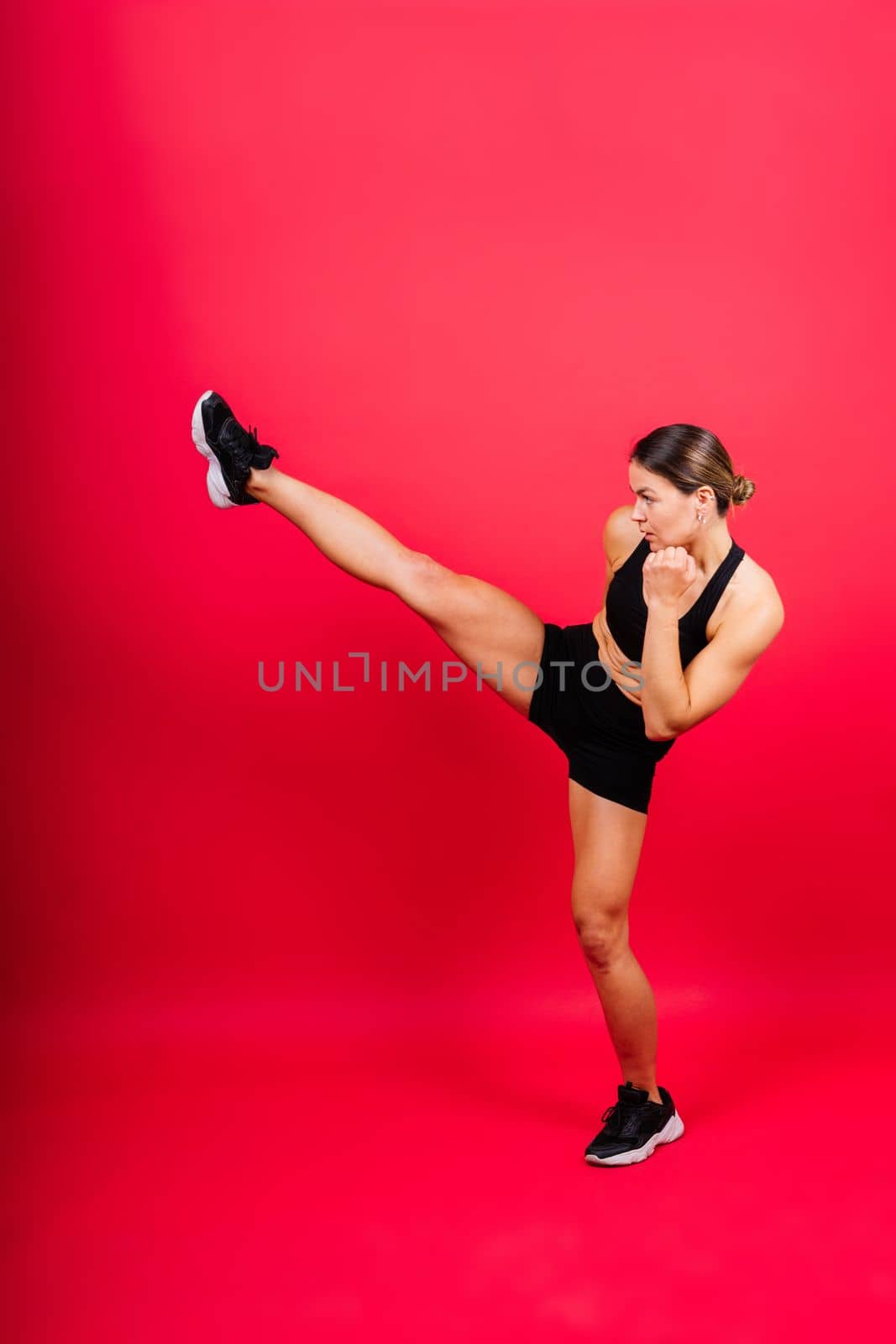 Woman do a high kick, tae-bo. Athletic fit female with perfect body kick air, punching with legs