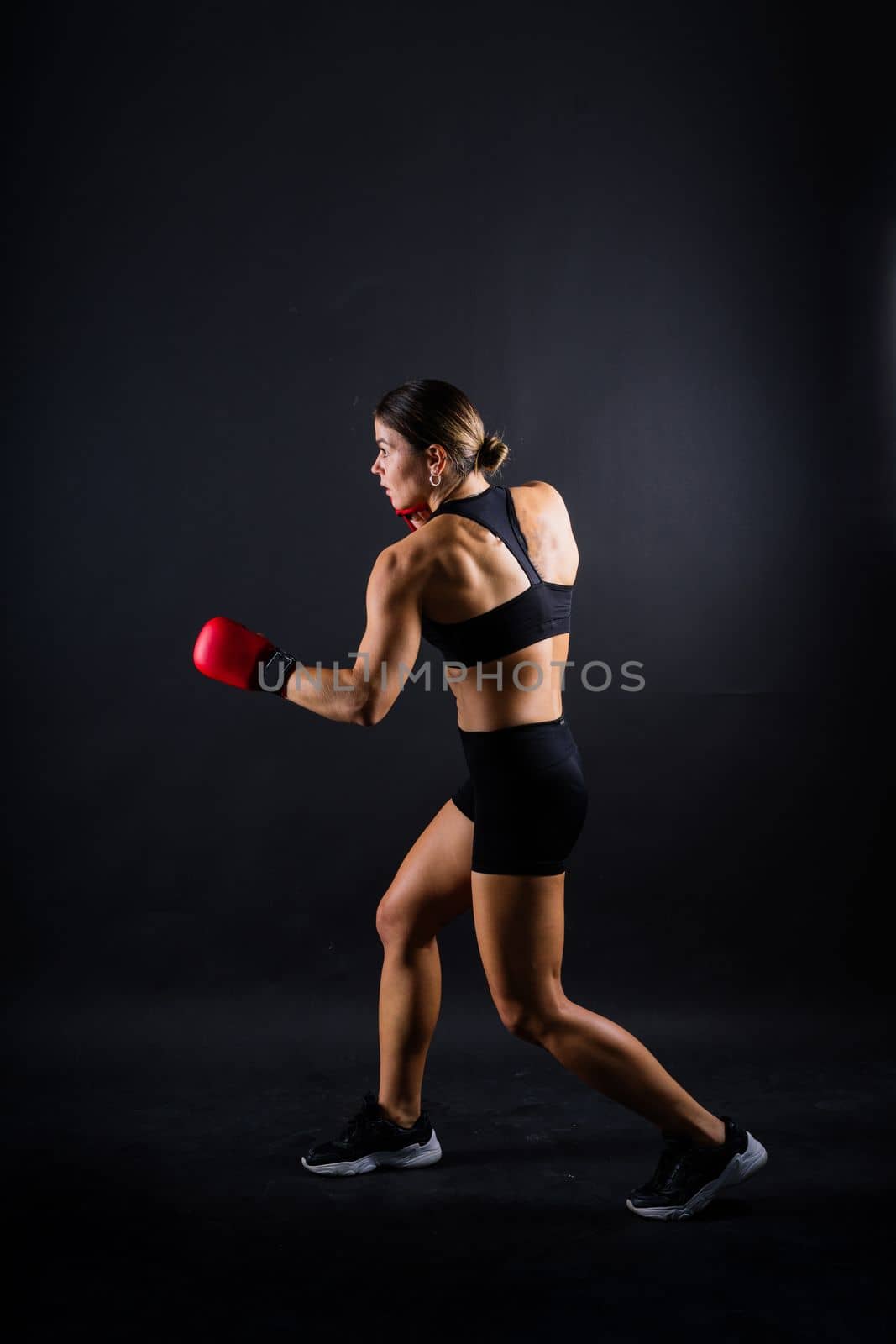 Woman do a high kick, tae-bo. Athletic fit female with perfect body kick air, punching with legs