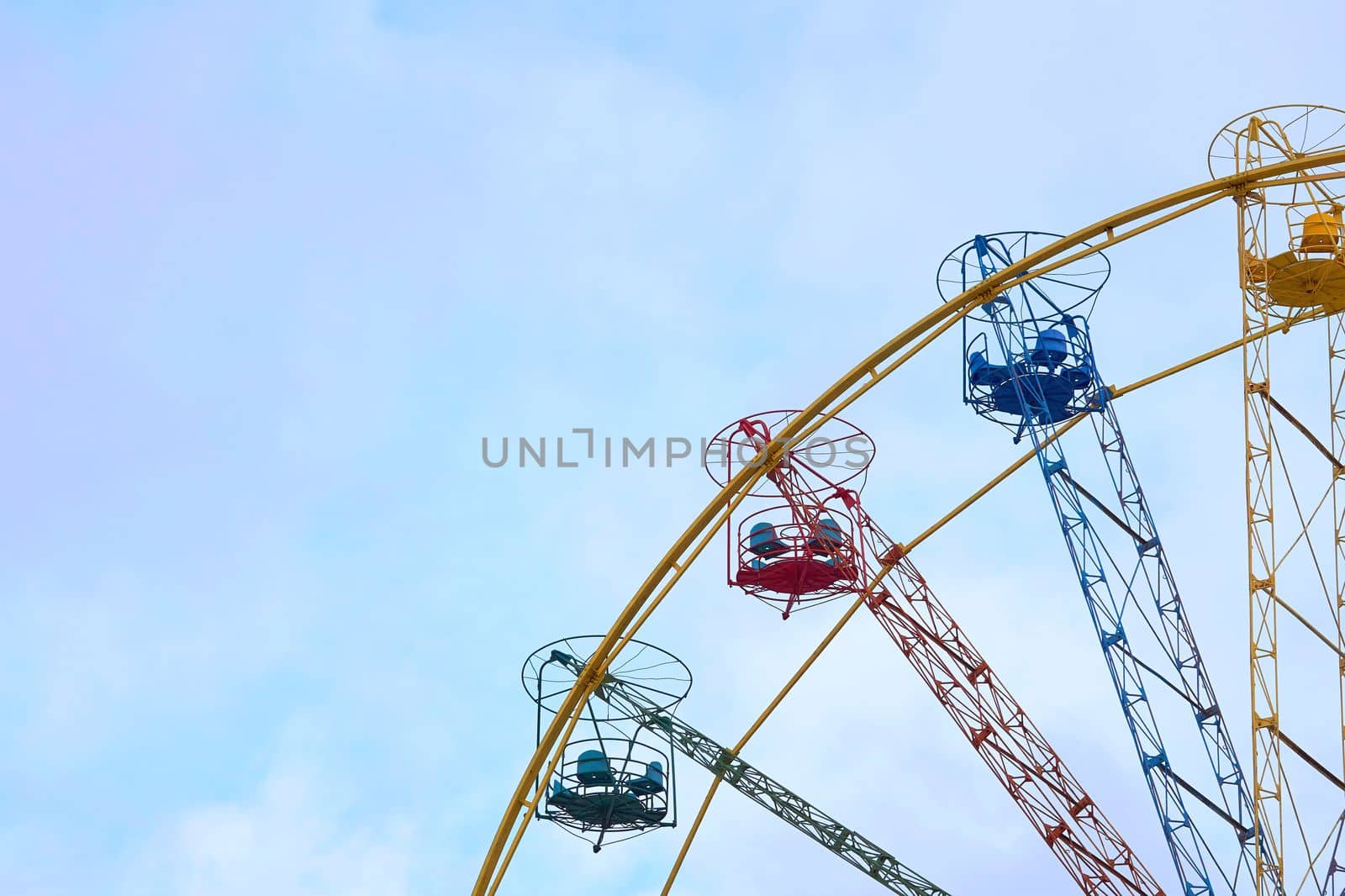 an amusement park or fairground ride consisting of a giant vertical revolving wheel with passenger cars suspended on its outer edge.