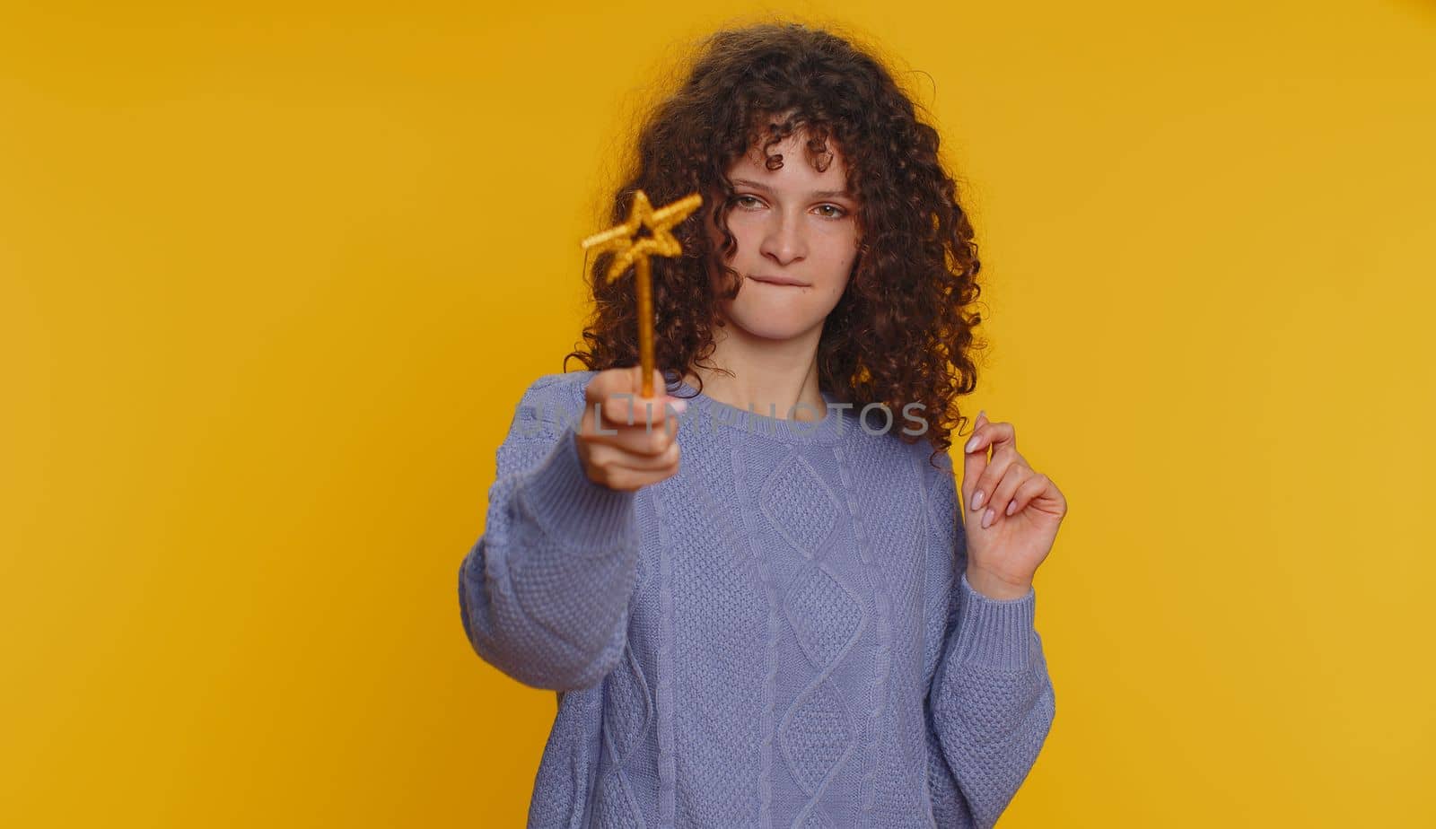 Magician witch woman gesturing with magic wand fairy stick, making wish come true, casting magician spell, advertising holidays sale discount. Young teen girl isolated on yellow studio background
