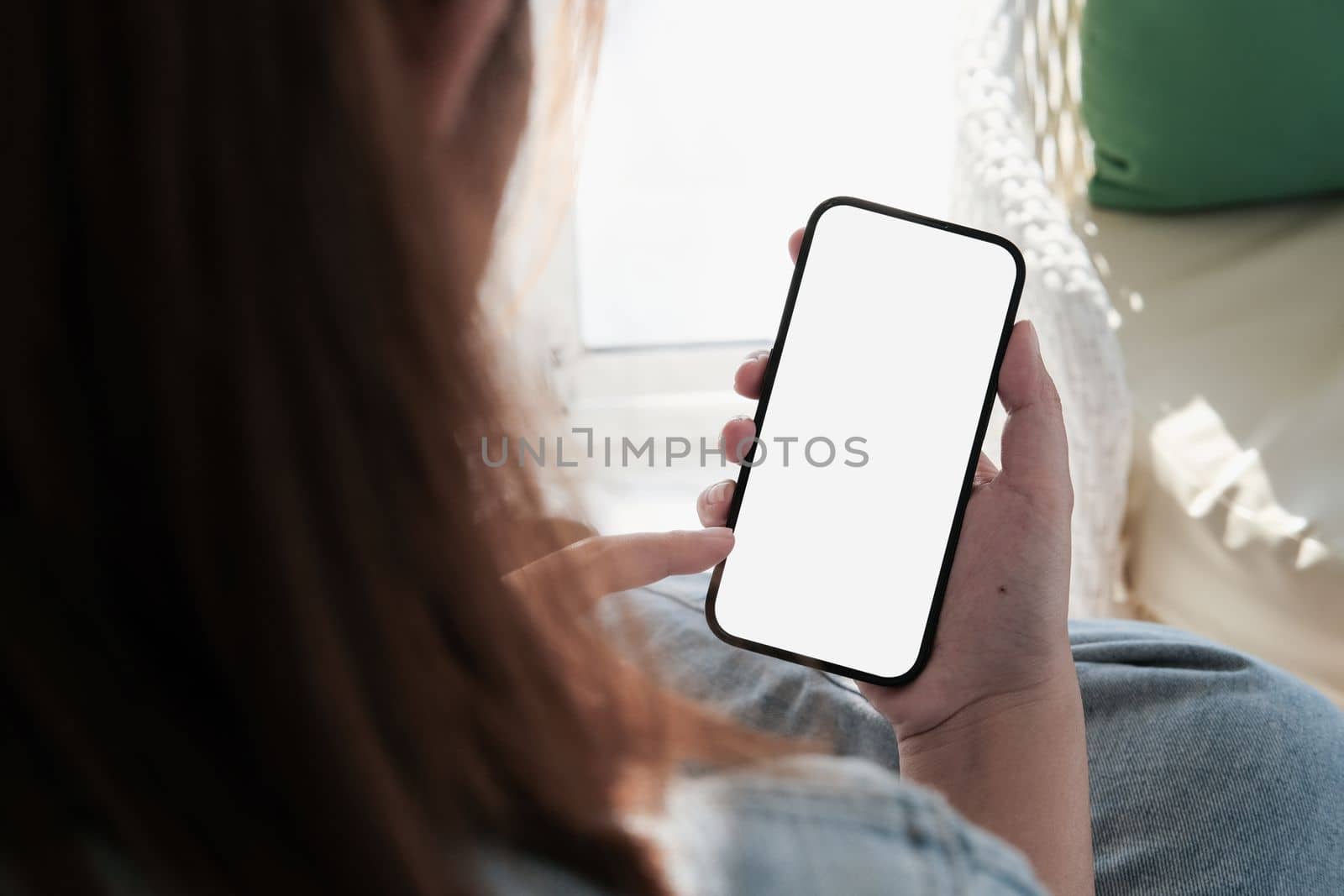 Mock up phone in woman hand showing white screen. Mobile phone white screen is blank the background is blurred by nateemee