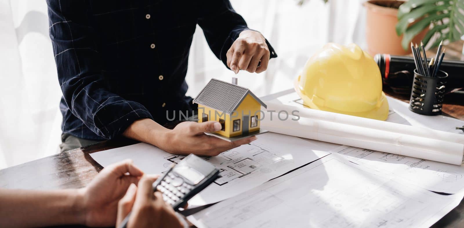 Civil engineer teams meeting working together wear worker helmets hardhat on construction site in modern city. Foreman industry project manager engineer teamwork. Asian industry professional team. by wichayada