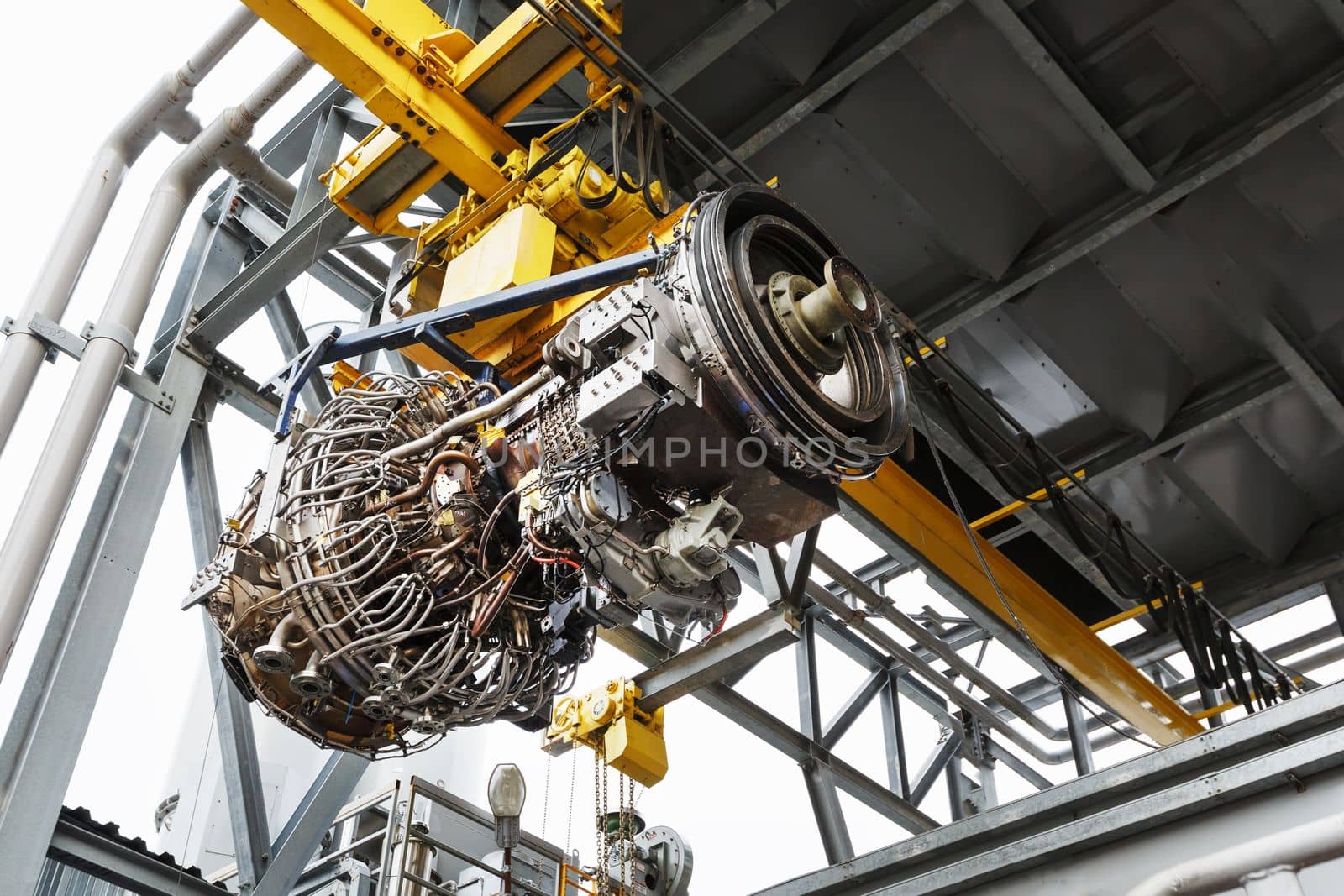 The engine of a gas turbine compressor hangs on a crane during installation in a module for generating electricity