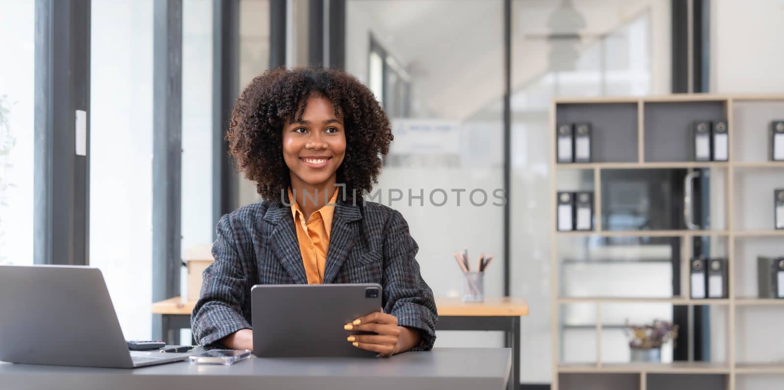 Asian Business woman using calculator and laptop for doing math finance on an office desk, tax, report, accounting, statistics, and analytical research concept..