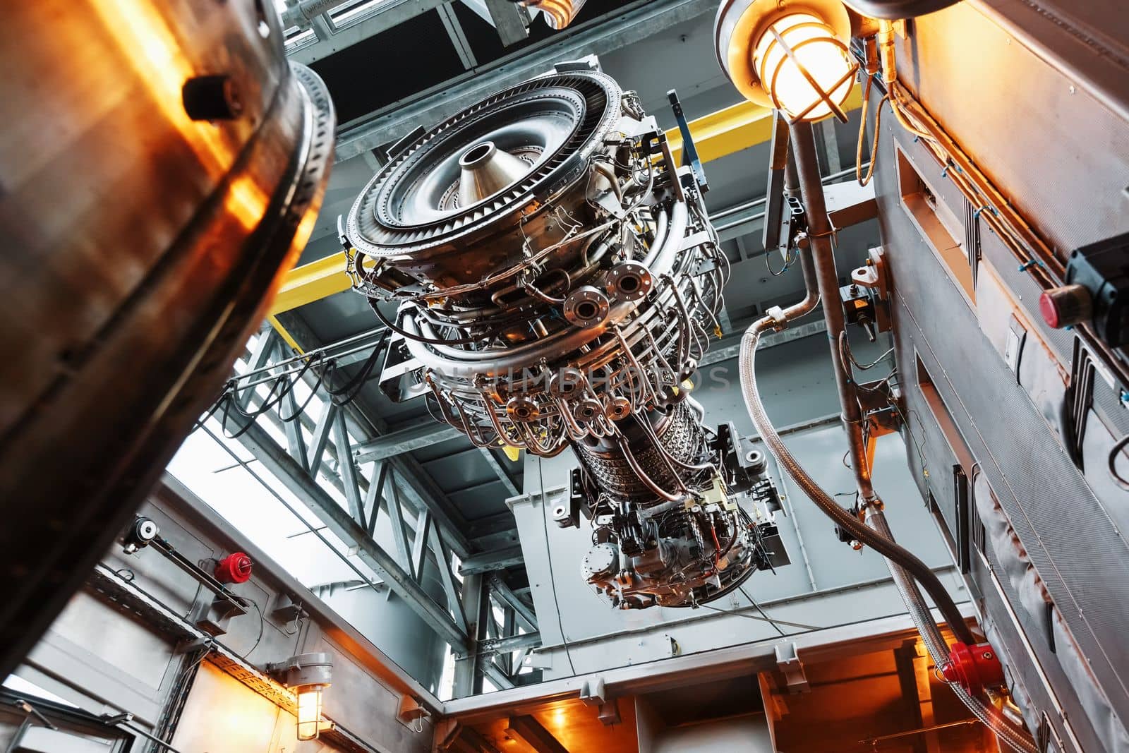 The engine of a gas turbine compressor hangs on a crane during installation in a module for generating electricity