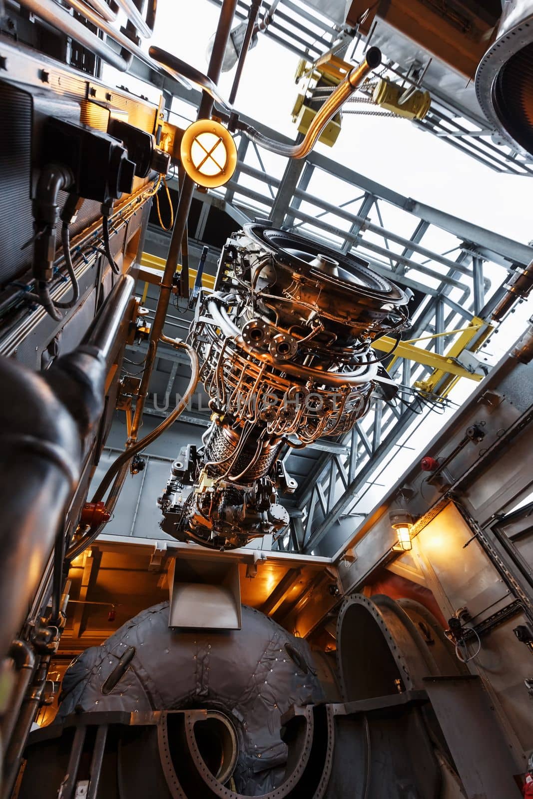 The engine of a gas turbine compressor hangs on a crane during installation in a module for generating electricity