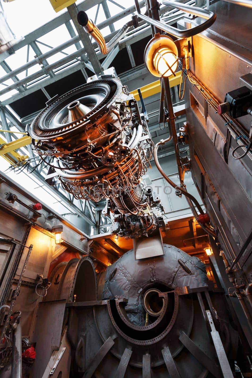 The engine of a gas turbine compressor hangs on a crane during installation in a module for generating electricity