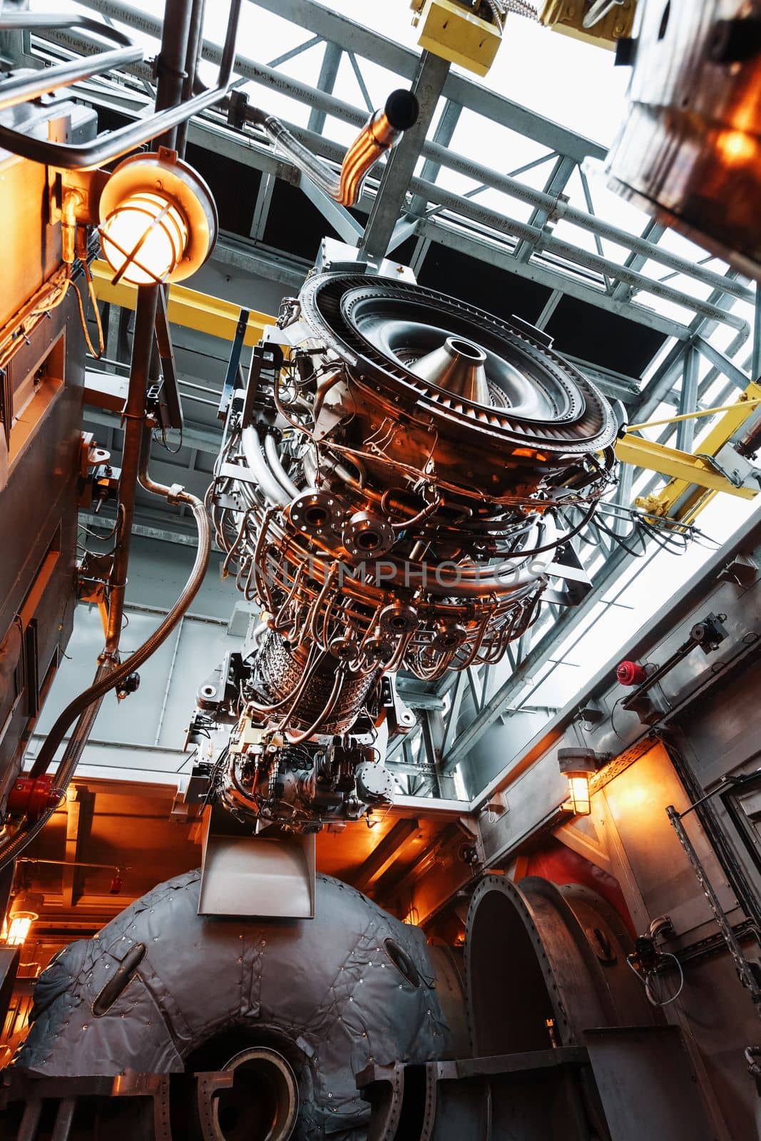 The engine of a gas turbine compressor hangs on a crane during installation in a module for generating electricity