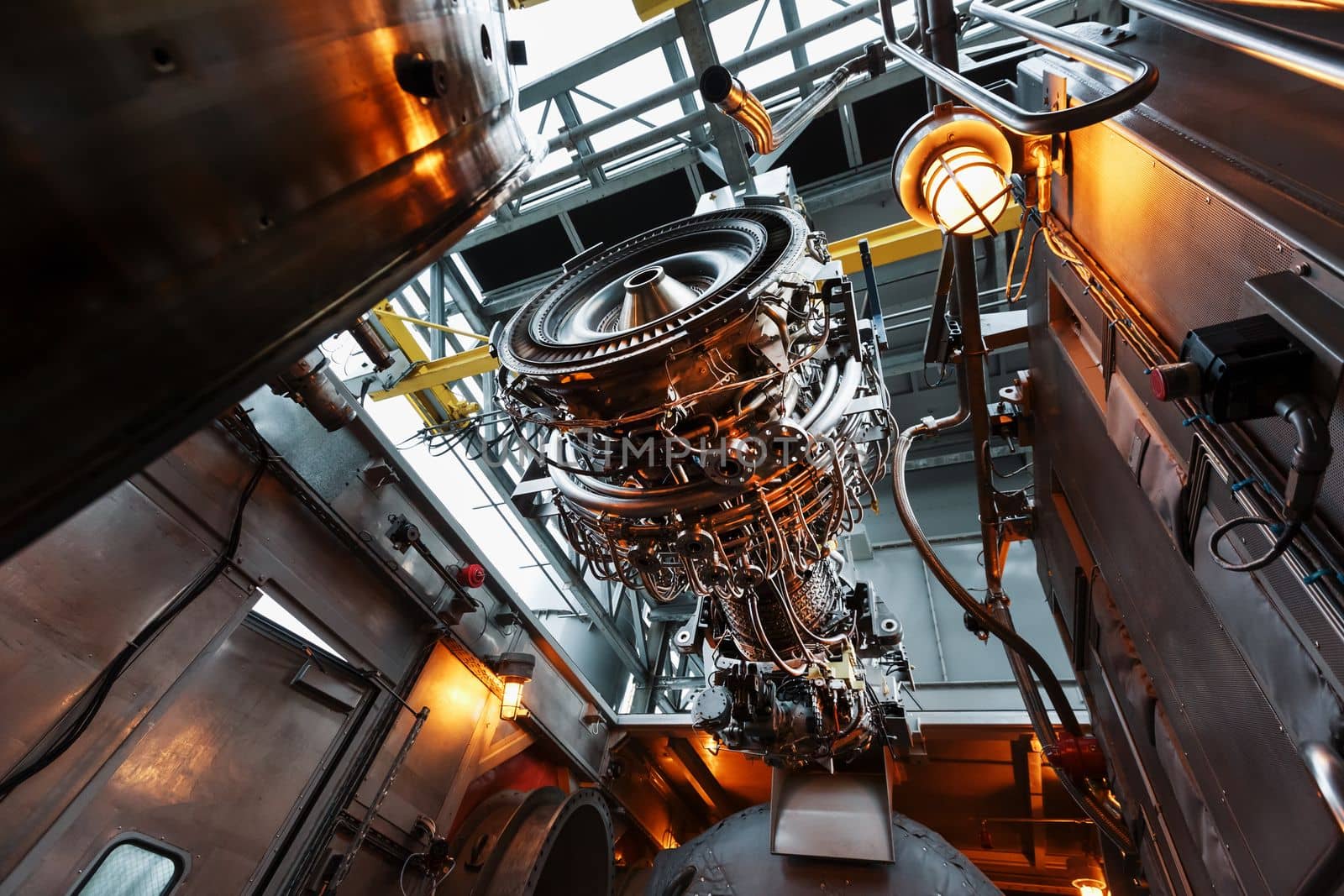 The engine of a gas turbine compressor hangs on a crane during installation in a module for generating electricity