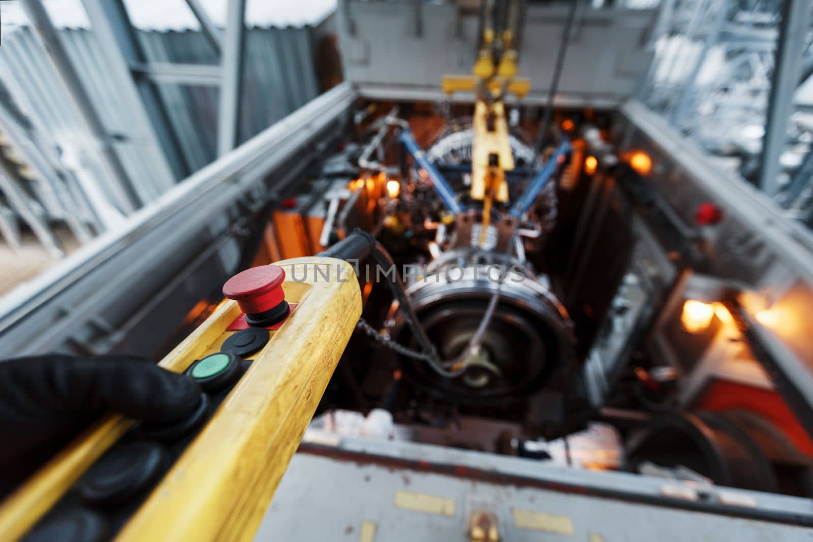 Yellow remote control of a crane with a red button when installing a gas turbine by AlexGrec