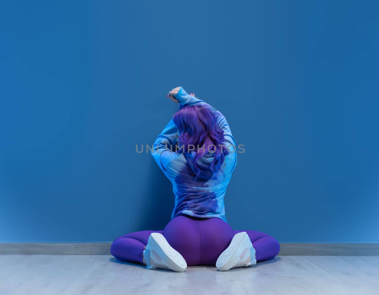 sexy girl in stylish purple sportswear sexy on the floor on a blank background copy paste by Rotozey