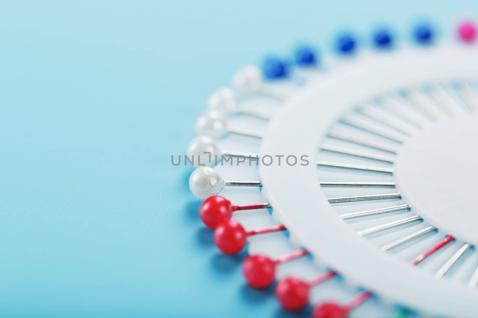 A set of multicolored needles pins in a round platform by AlexGrec
