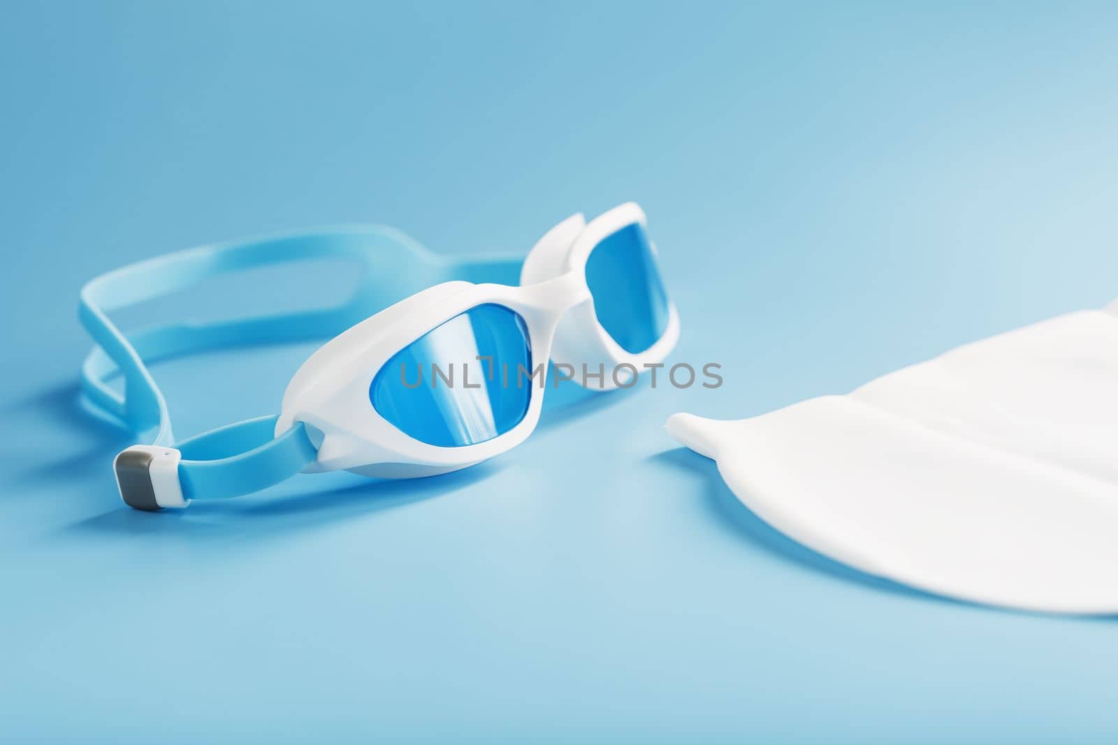 White swimming glasses in hand on a blue background with a white cap by AlexGrec