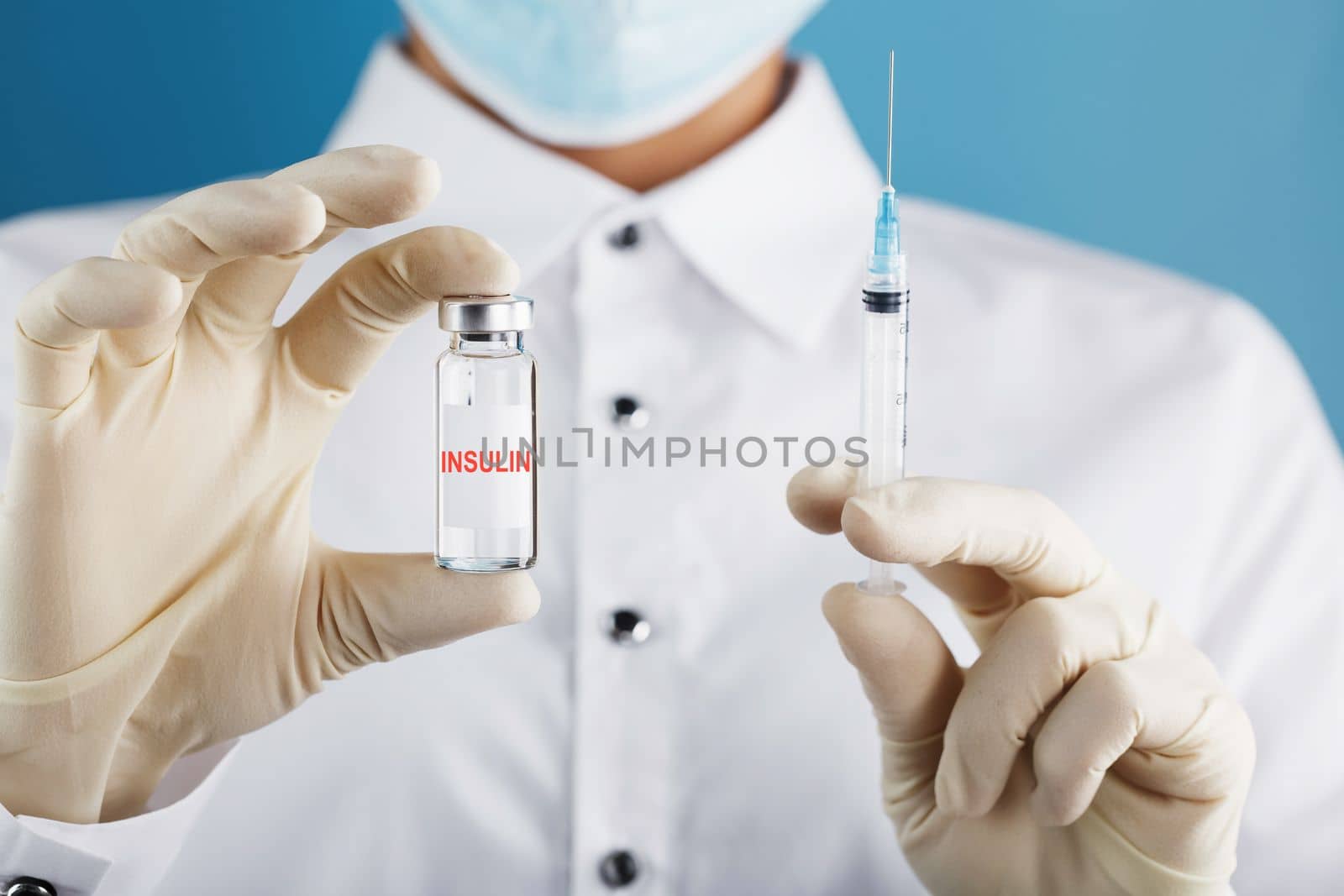 Diabetes treatment a bottle of insulin and a syringe with a needle in the hands of a doctor by AlexGrec