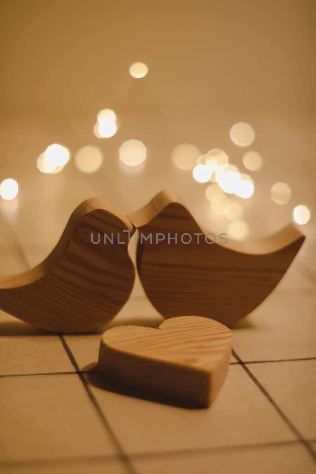 two wooden birds and heart made by bokeh lights background. Valentines day, Easter, Wedding card with wooden figures of birds, home decor.