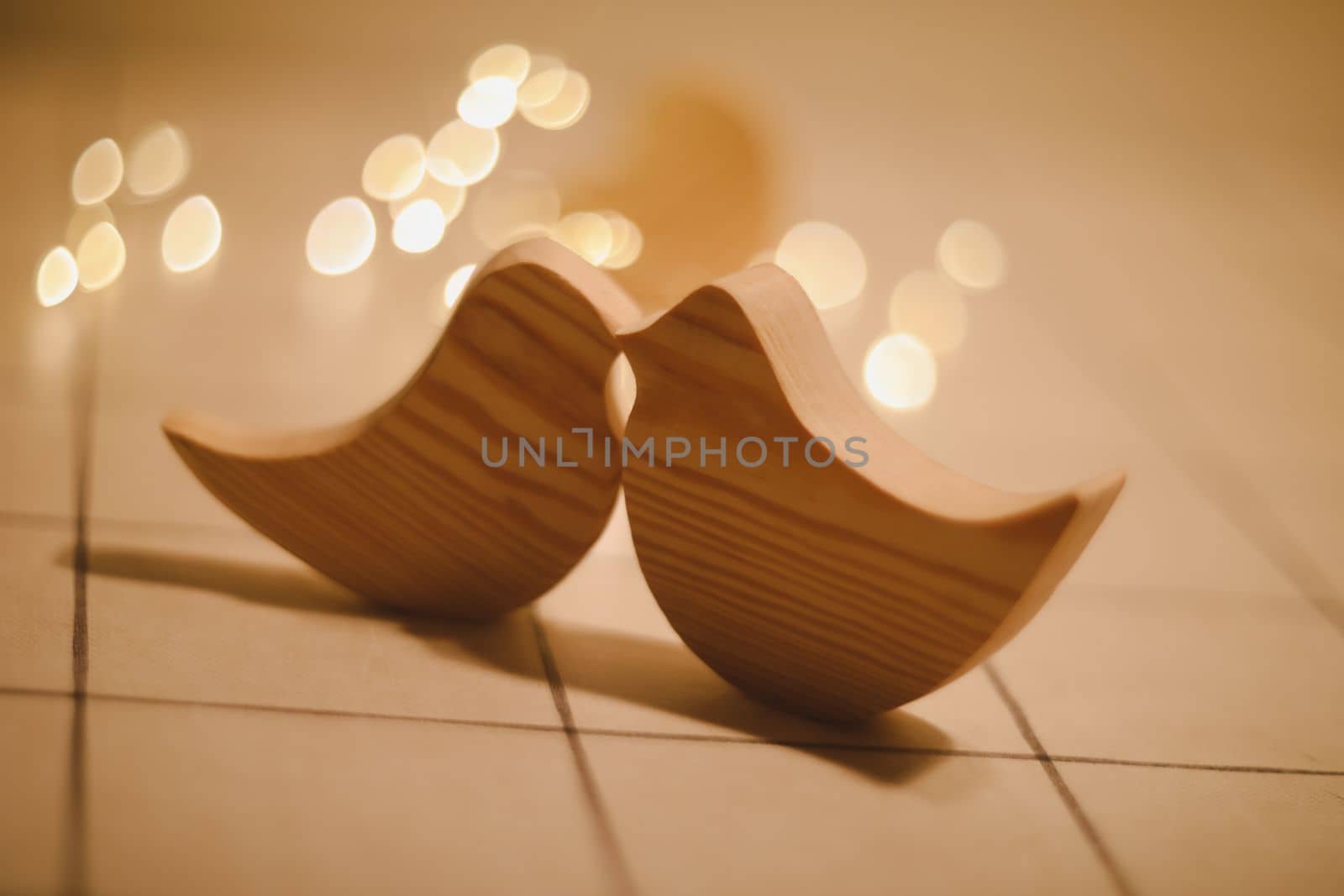 two wooden birds and heart made by bokeh lights background. Valentines day, Easter, Wedding card with wooden figures of birds, home decor.