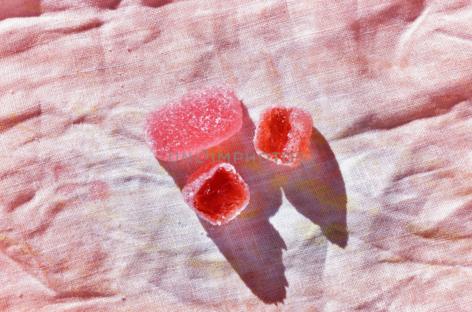 Red  sugar fruit candies on colored background  ,ready to eat unhealthy sweets