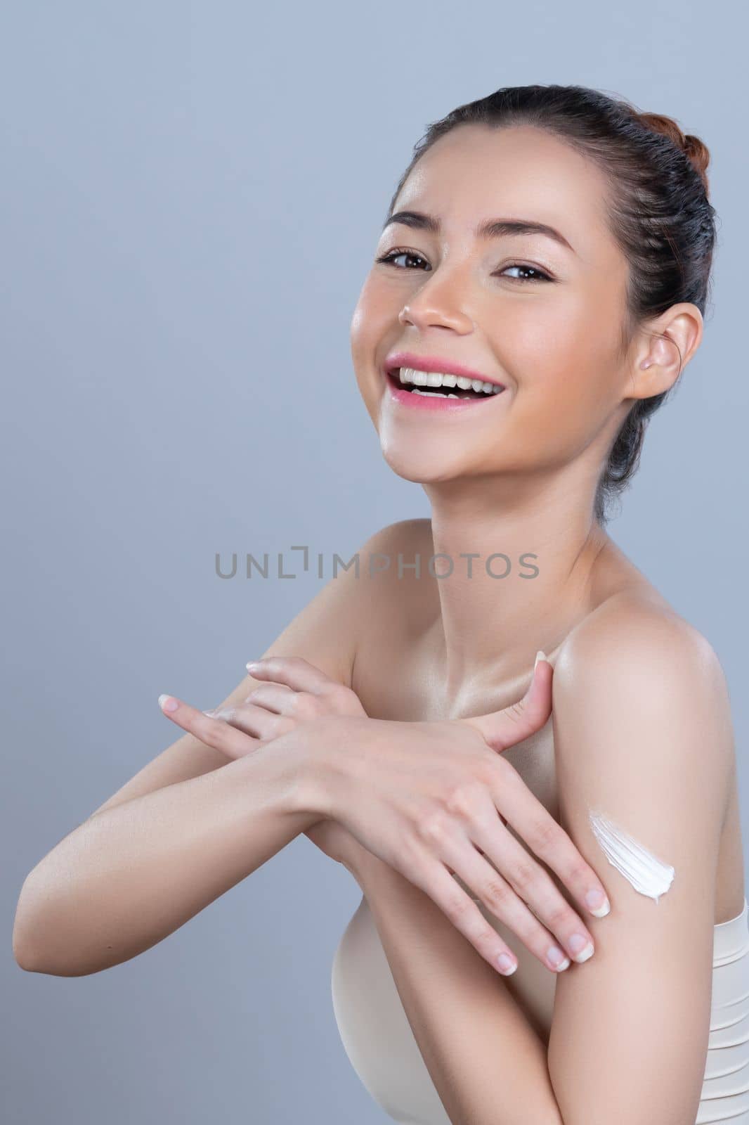 Glamorous beautiful woman applying moisturizer cream on her arm for perfect skin by biancoblue