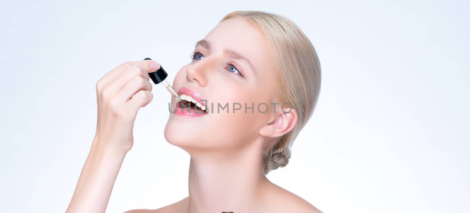 Closeup personable portrait of beautiful woman applying essential oil bottle for skincare product. Cannabis extracted CBD oil dropper for treatment and cannabinoids concept in isolated background.