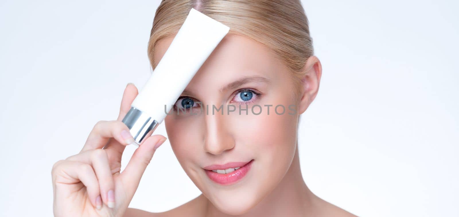 Closeup personable beautiful perfect natural skin woman hold mockup tube moisturizer cream for skincare treatment product advertising expressive facial and gesture expression in isolated background.